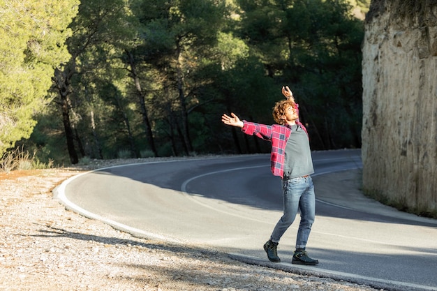 Side view of happy man enjoying nature while on a road trip