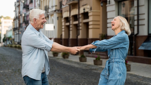 Free photo side view of happy senior couple spending time in the city