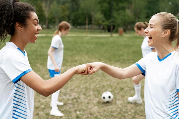 Side view happy women fist bump