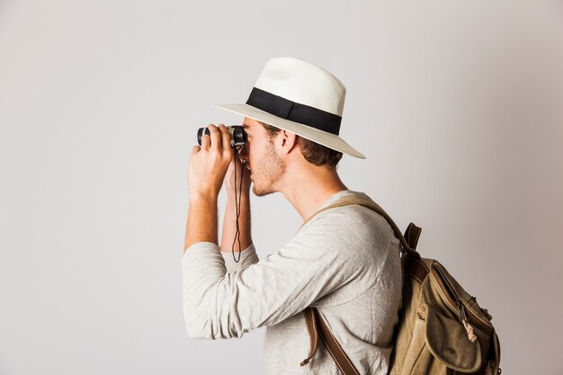 Side view of hipster man using binoculars