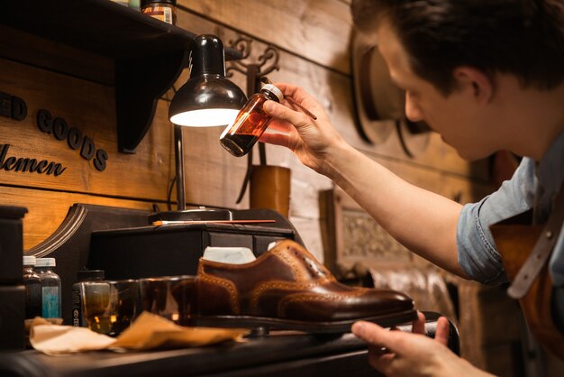 Side view image of young concentrated shoemaker