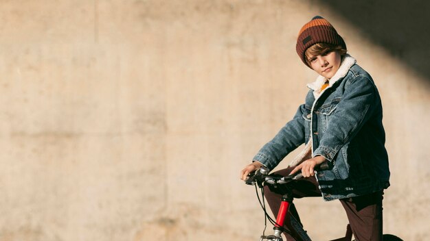 Side view of kid on bike outdoors with copy space