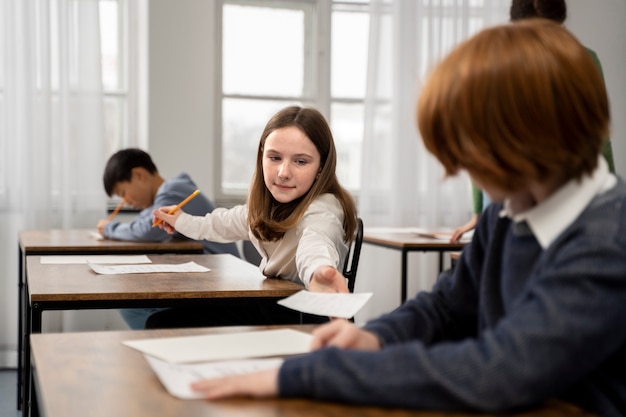 Free photo side view kid cheating at school test