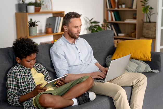 Free photo side view kid and parent with devices