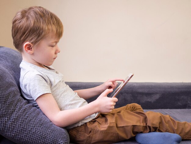 Side view kid playing on tablet