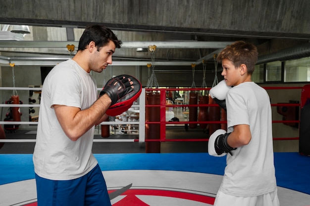 Free photo side view kid practicing boxing