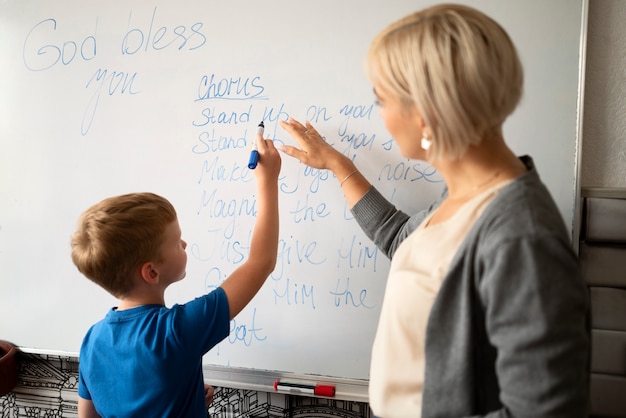 Side view kid writing on whiteboard