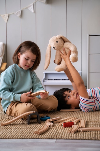 Free Photo side view kids playing  playing with toys