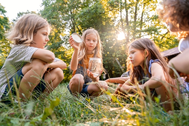 Side view kids sitting on grass