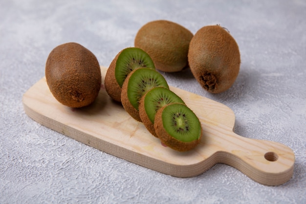 Side view kiwi on a cutting board on a white background