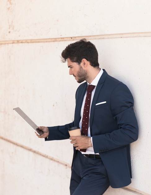 Free photo side view lawyer looking at his tablet