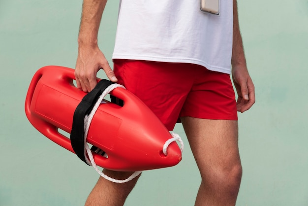 Free Photo side view lifeguard holding lifesaving buoy