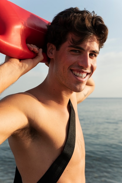 Side view lifeguard holding lifesaving buoy