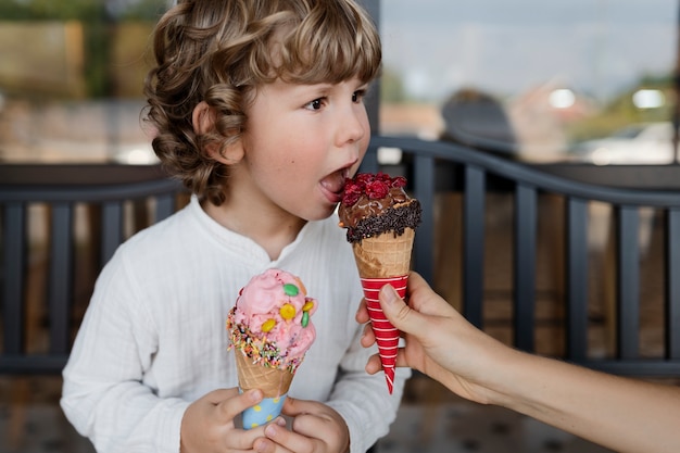 Side view little boy licking ice cream cone