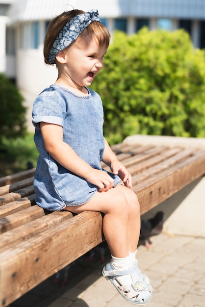 Side view of little girl on bench