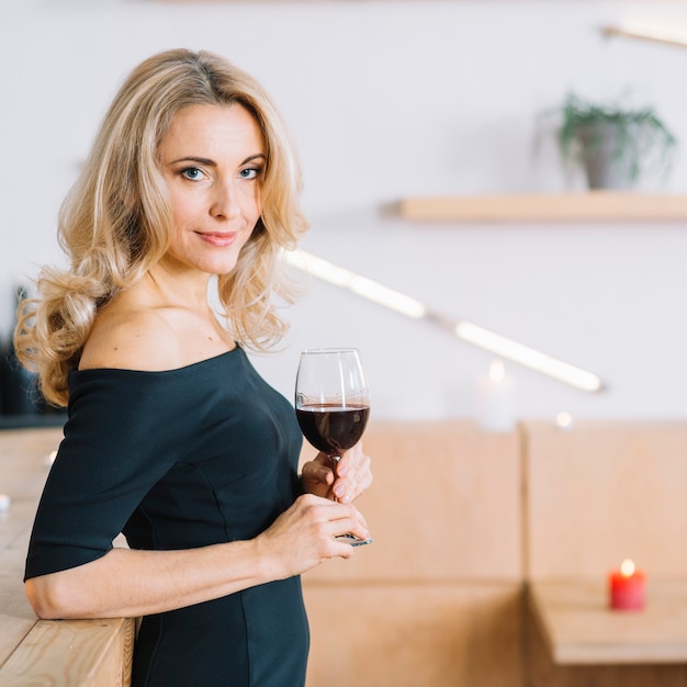 Side view of lovely woman holding glass of wine