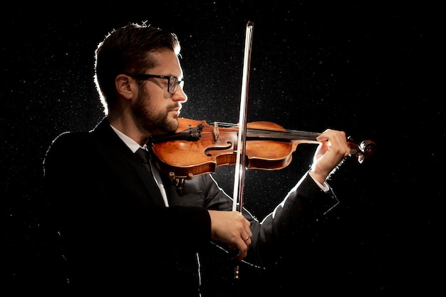 Free Photo side view of male artist playing violin