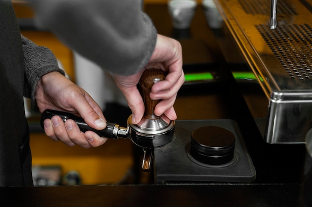 Side view of male barista with coffee machine