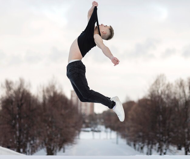 Side view of male dancer posing while in the air