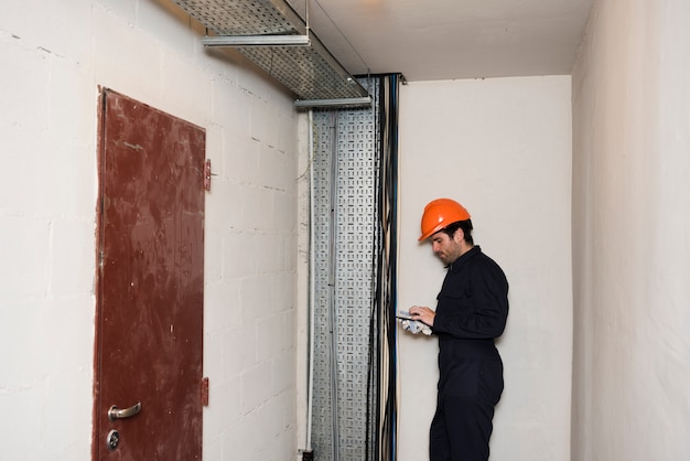 Free Photo side view of male electrician using mobile phone at work