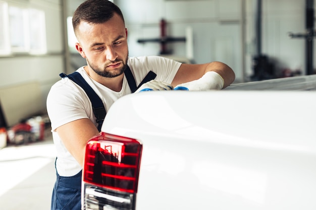 Side view male mechanic checking car back