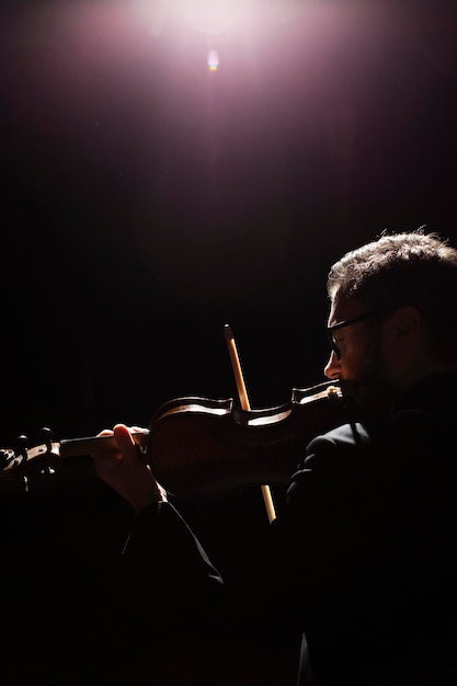 Side view of male musician playing the violin with copy space