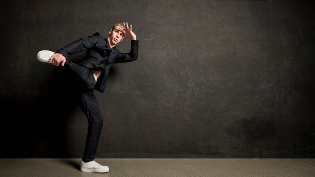 Side view of male performer in suit posing with copy space