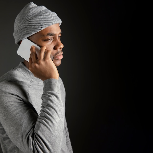 Free photo side view male wearing cap talking on phone