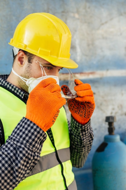 Side view of male worker with protective glasses and reflective vest