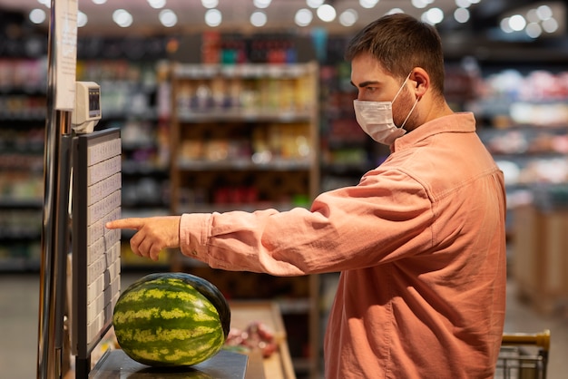 Free Photo side view man buying watermelon