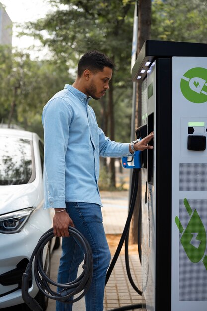 Side view man charging electric car