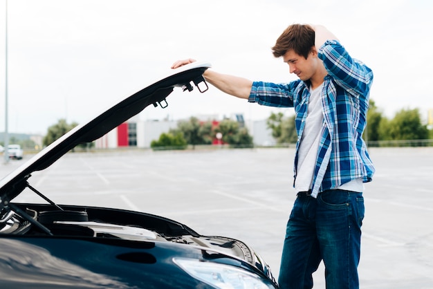 Side view of man checking engine