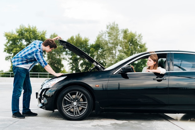 Side view of man checking engine