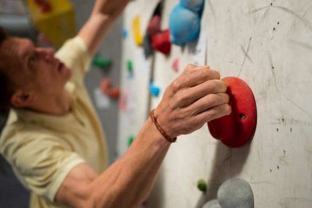 Free Photo side view man climbing wall