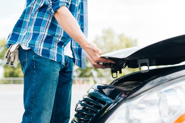 Free Photo side view of man closing car hood