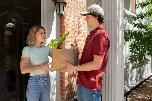 Free photo side view man delivering groceries