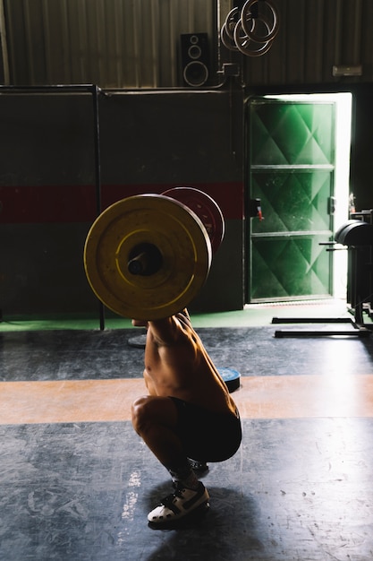 Side view of man doing weighlifting