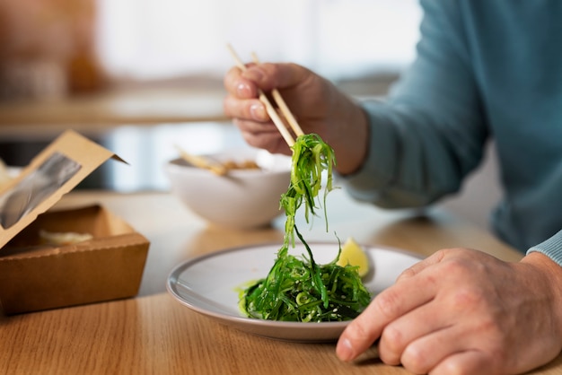 Free photo side view man eating asian food