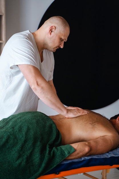 Side view man getting professional massage