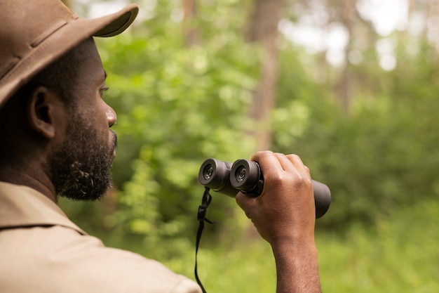 Side view man holding binoculars