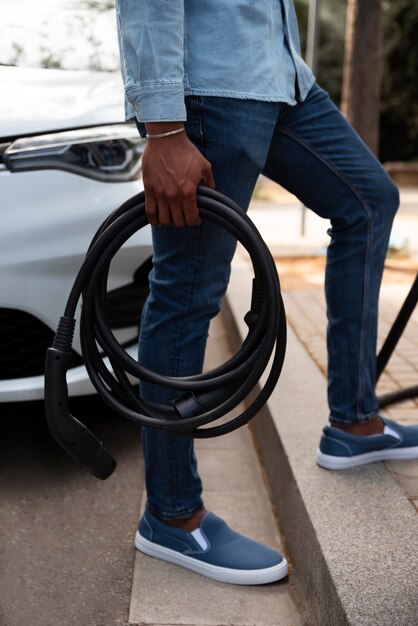 Side view man holding charging cable