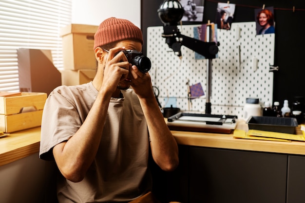 Free photo side view man holding photo camera