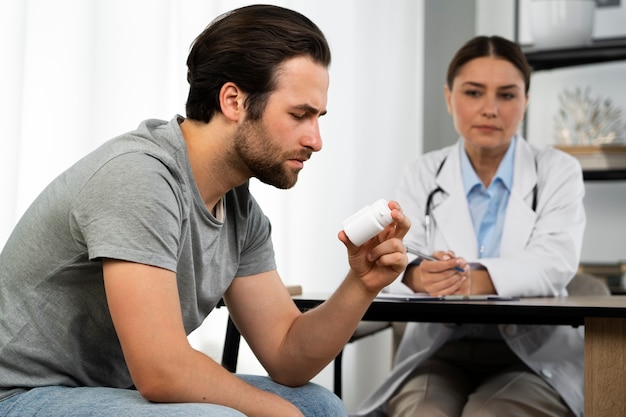 Side view man holding pills container