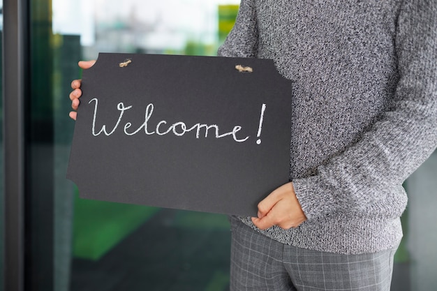 Free Photo side view man holding welcome signs