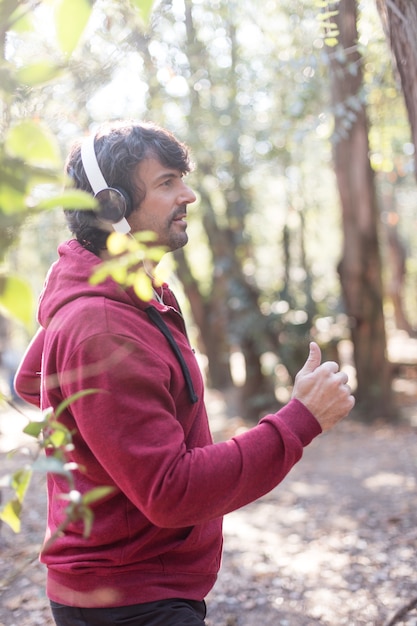 Free Photo side view of man in hoodie running in the park