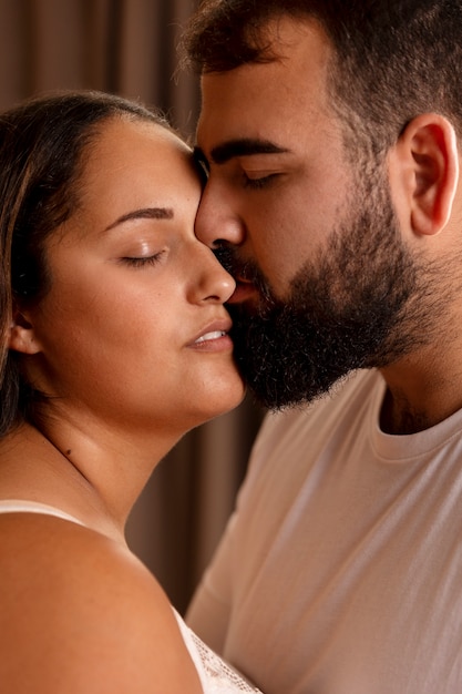 Side view man kissing woman on cheek