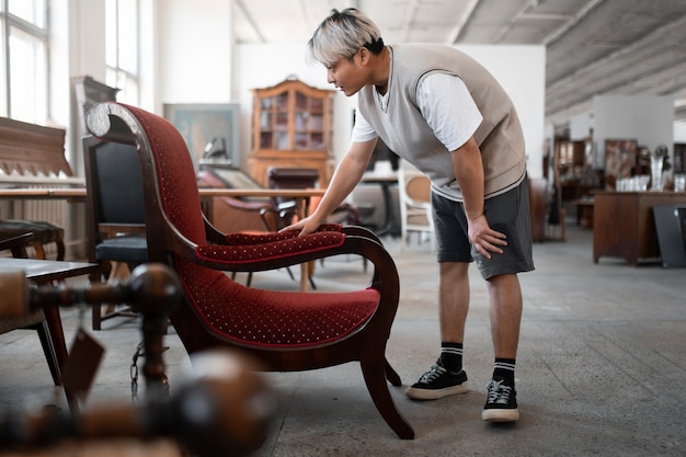 Free photo side view man looking at chair