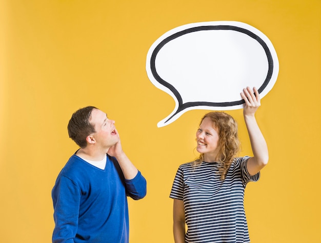 Free photo side view of man looking at chat bubble woman is holding