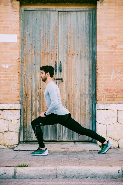 Side view man lunging near door