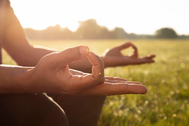 Free photo side view of man meditating outdoors